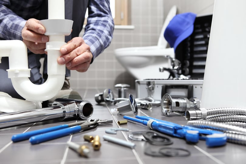 Image showing a professional plumber inspecting a plumbing system with specialized tools.
